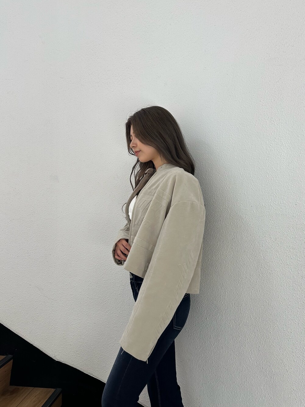 ブラック系のブーツ、ブルー系のデニムパンツ、ホワイト系のチューブトップを着用したレディースの秋コーディネートの4枚目の写真