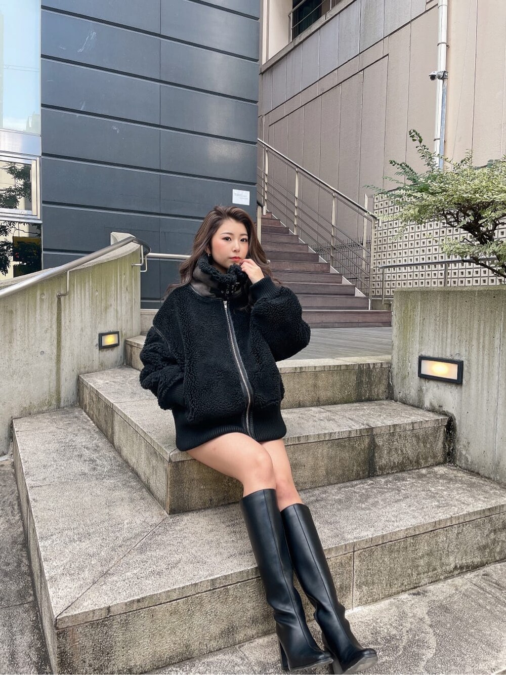 ベージュ系のニット/セーター、ブラック系のスカート、ブラウン系のブルゾンを着用したレディースの冬コーディネートの2枚目の写真