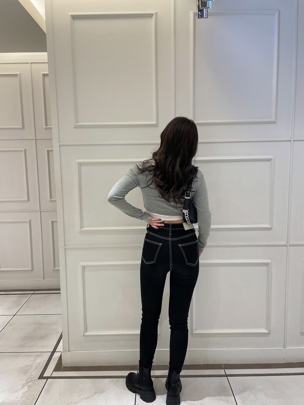 グレー系のTシャツ/カットソー、ブラック系のライダースジャケット、ブラック系のハンドバッグを着用したレディースの冬コーディネートの6枚目の写真