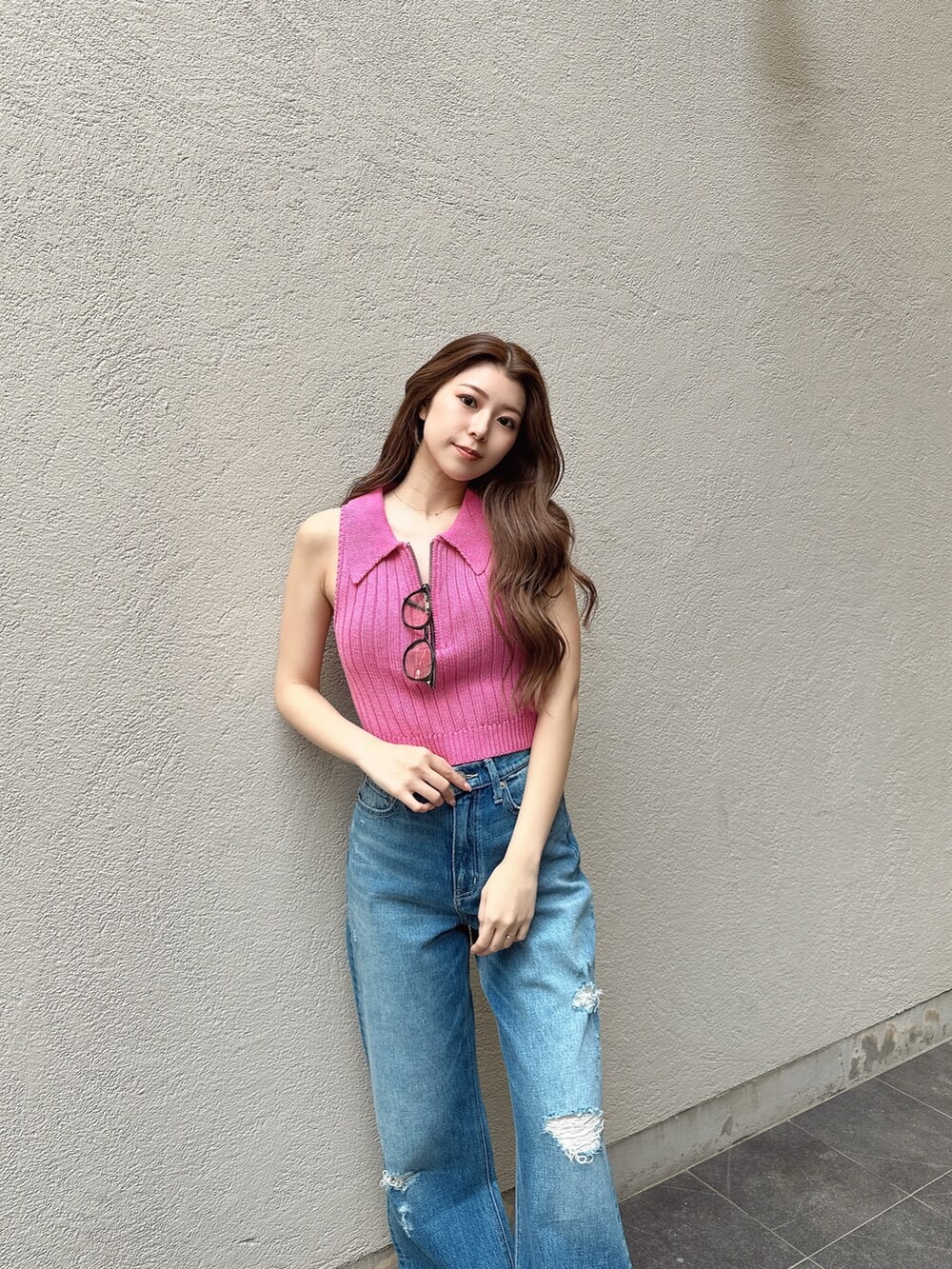 ピンク系のニット/セーター、ブルー系のデニムパンツを着用したレディースの夏コーディネートの3枚目の写真