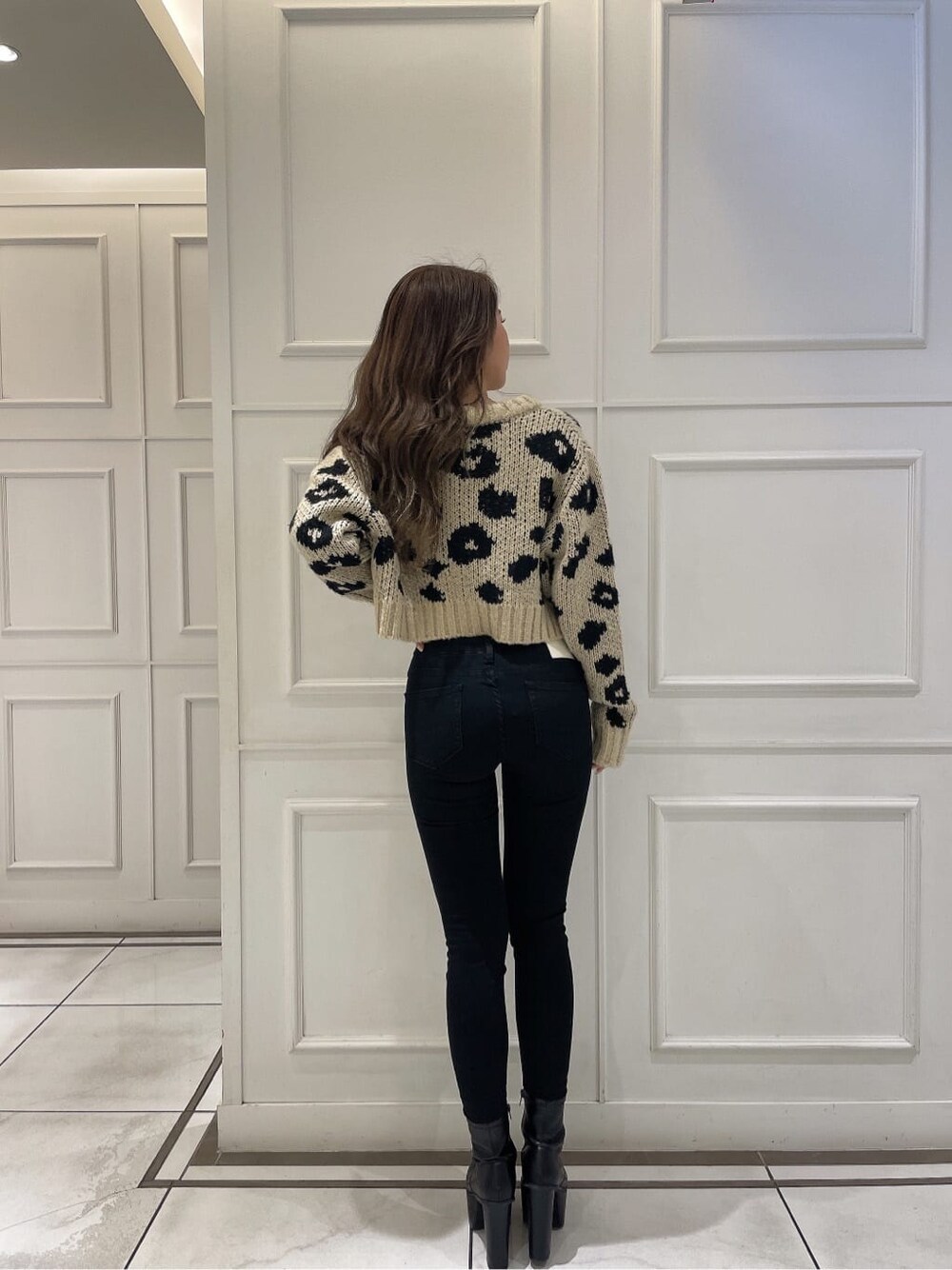 ブラック系のブーツ、ホワイト系のキャミソール、ベージュ系のカーディガン/ボレロを着用したレディースの秋コーディネートの4枚目の写真