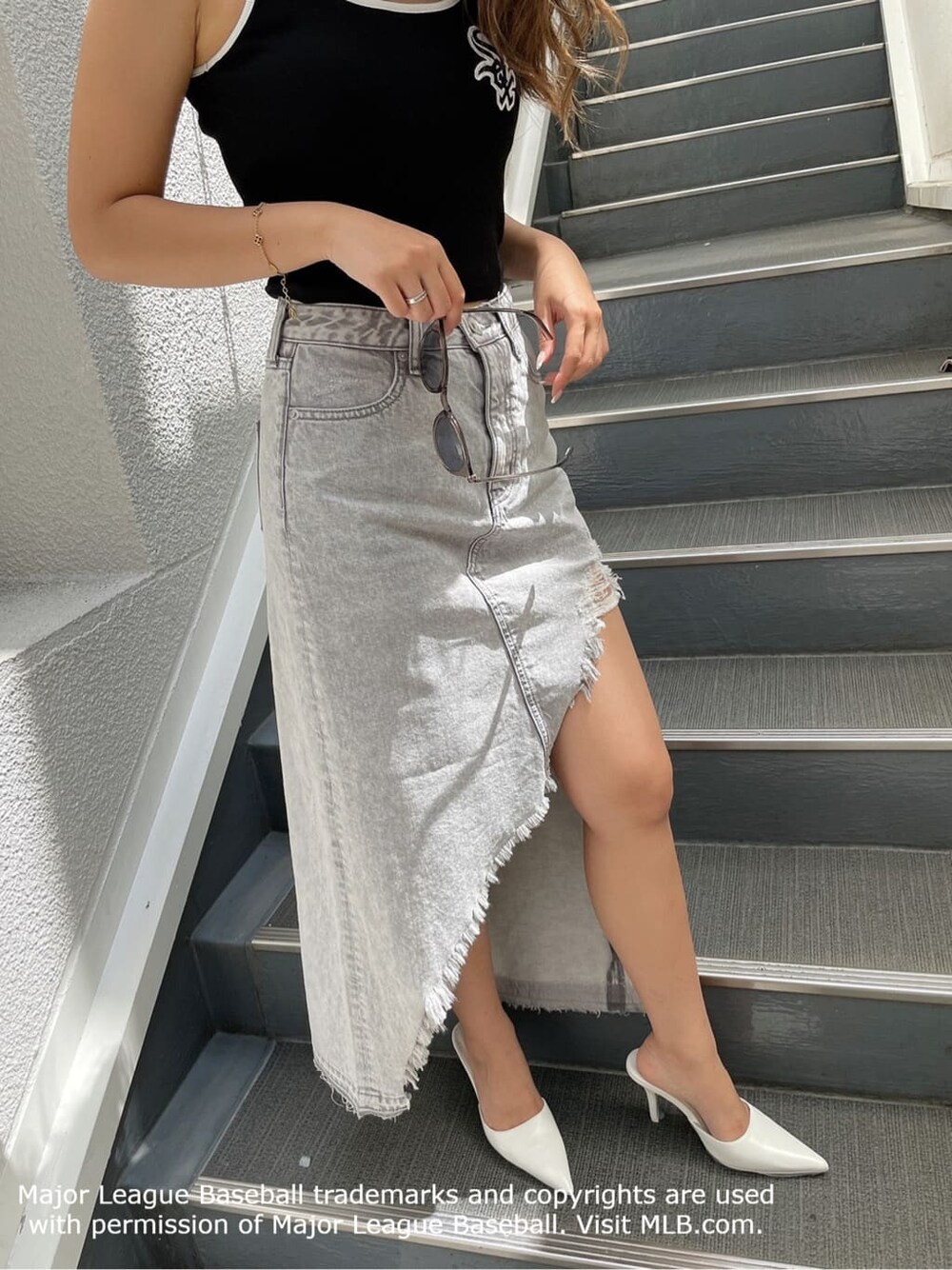 ホワイト系のパンプス、グレー系のデニムスカート、グレー系のパーカーを着用したレディースの夏コーディネートの9枚目の写真