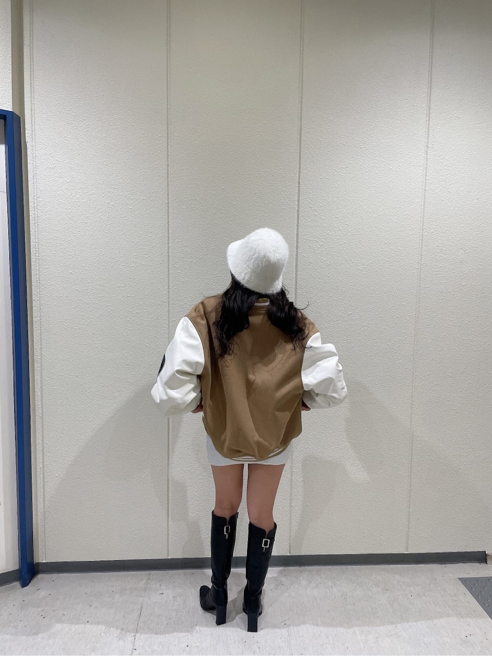 ベージュ系のスタジャン、ブラック系のブーツ、ホワイト系のワンピースを着用したレディースの秋コーディネートの3枚目の写真