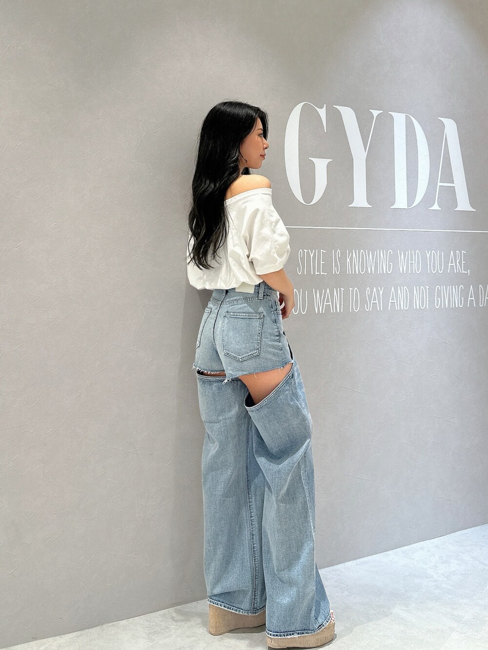 ホワイト系のサンダル、ホワイト系のTシャツ/カットソー、ブルー系のデニムパンツを着用したレディースの夏コーディネートの2枚目の写真