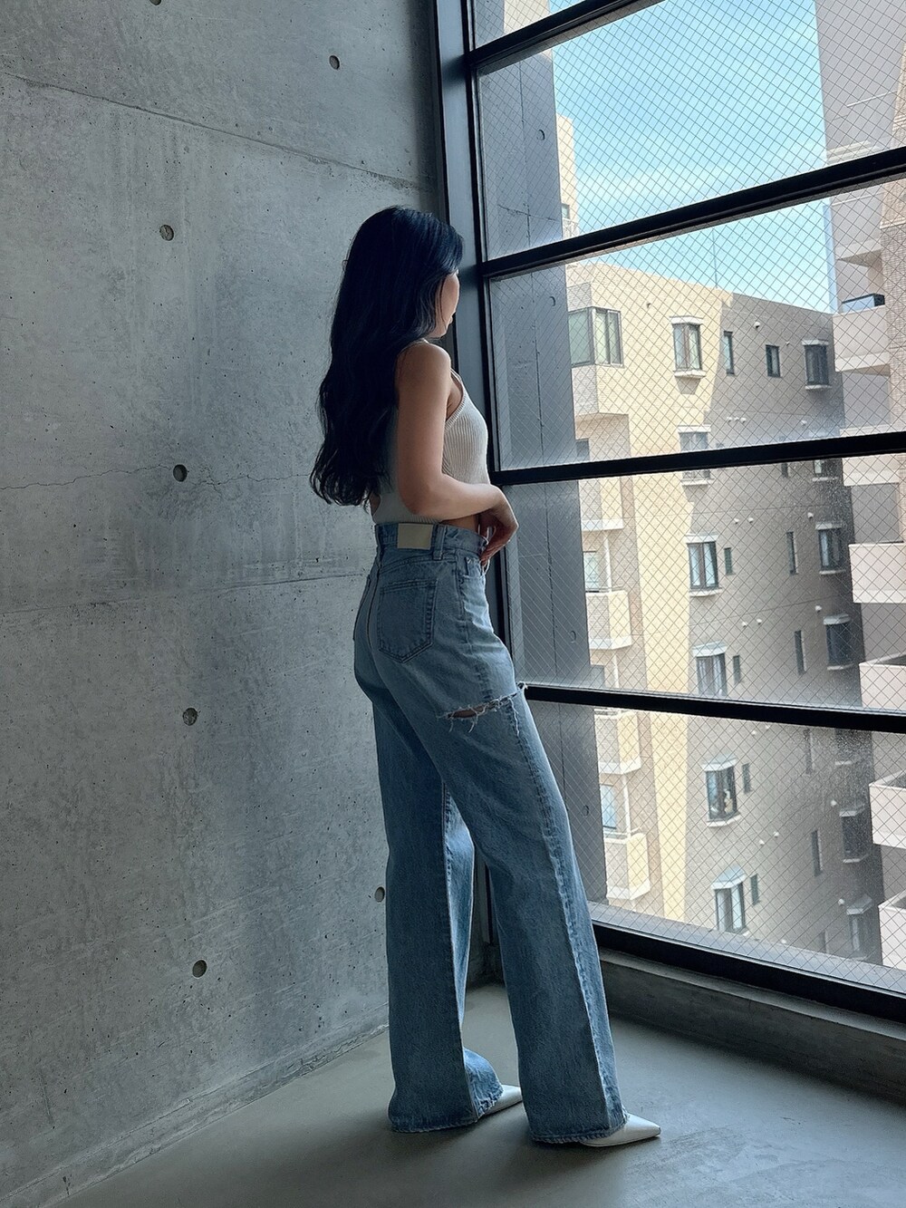 ホワイト系のパンプス、ホワイト系のタンクトップ、ブルー系のデニムパンツを着用したレディースの夏コーディネートの3枚目の写真