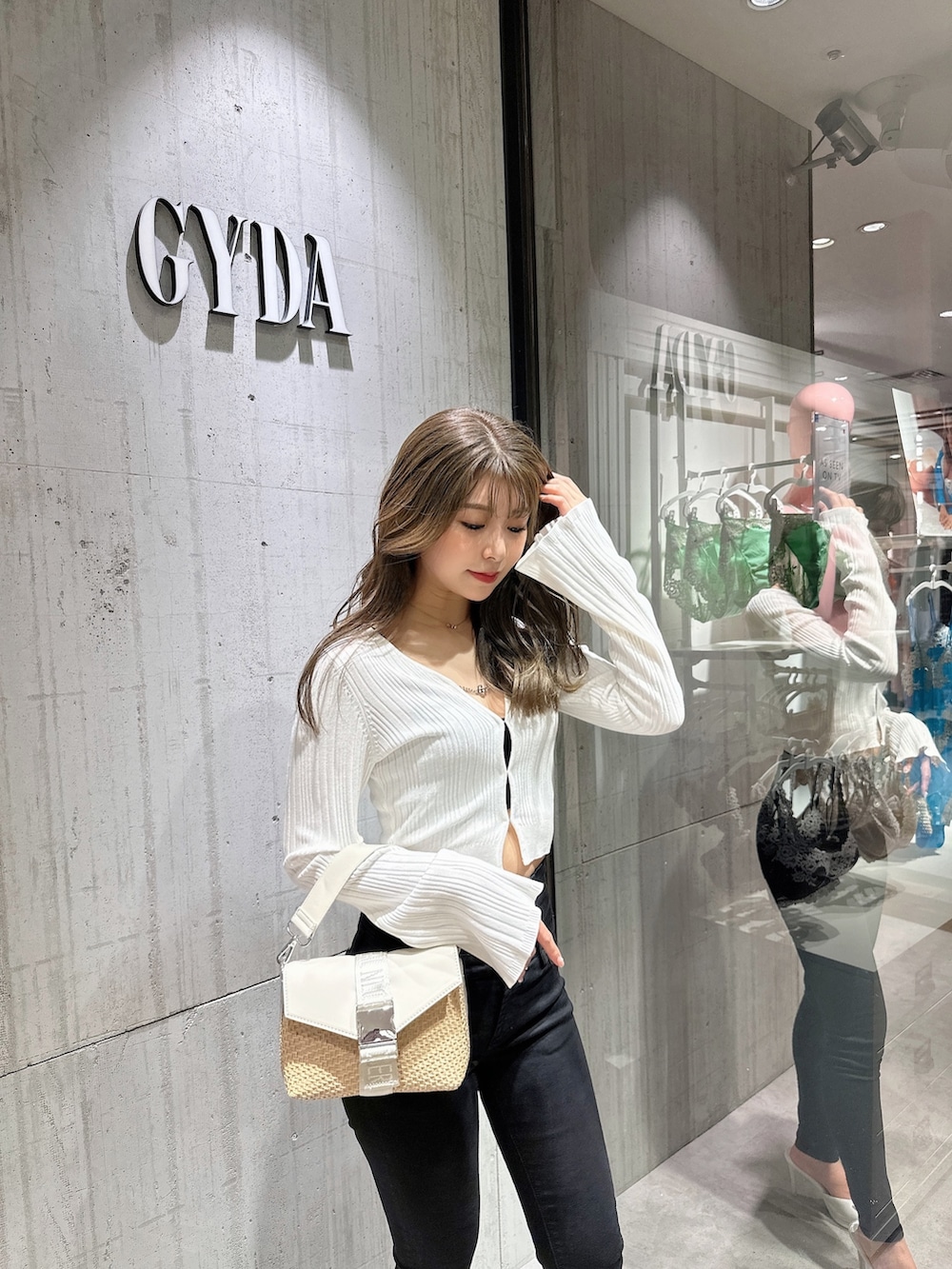 ホワイト系のカーディガン/ボレロ、ブラック系のデニムパンツ、ホワイト系のパンプスを着用したレディースの夏コーディネートの5枚目の写真