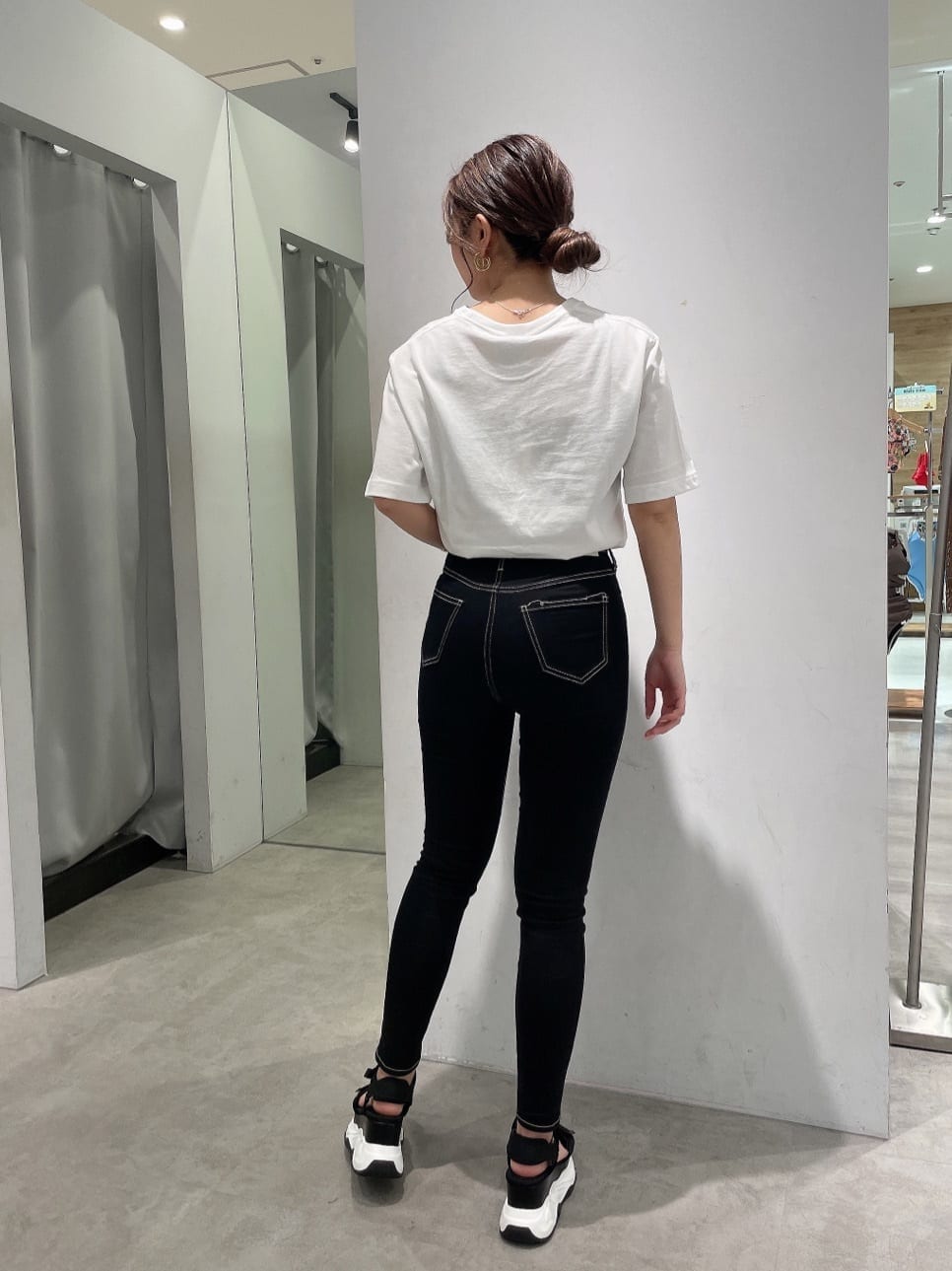 ブラック系のデニムパンツ、その他のサンダル、ホワイト系のTシャツ/カットソーを着用したレディースの春コーディネートの3枚目の写真