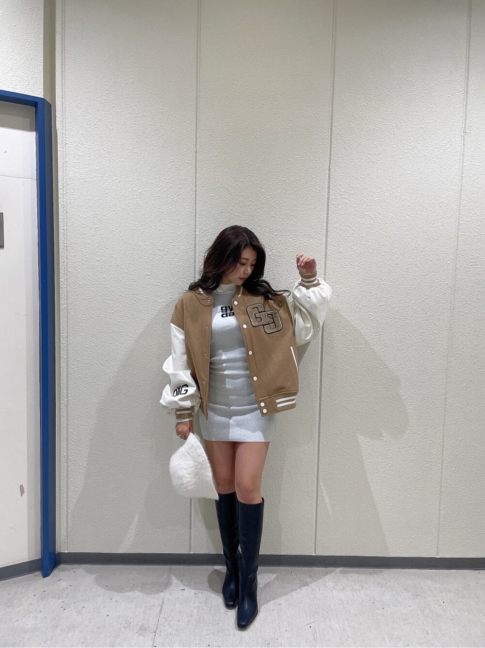 ベージュ系のスタジャン、ブラック系のブーツ、ホワイト系のワンピースを着用したレディースの秋コーディネートの4枚目の写真