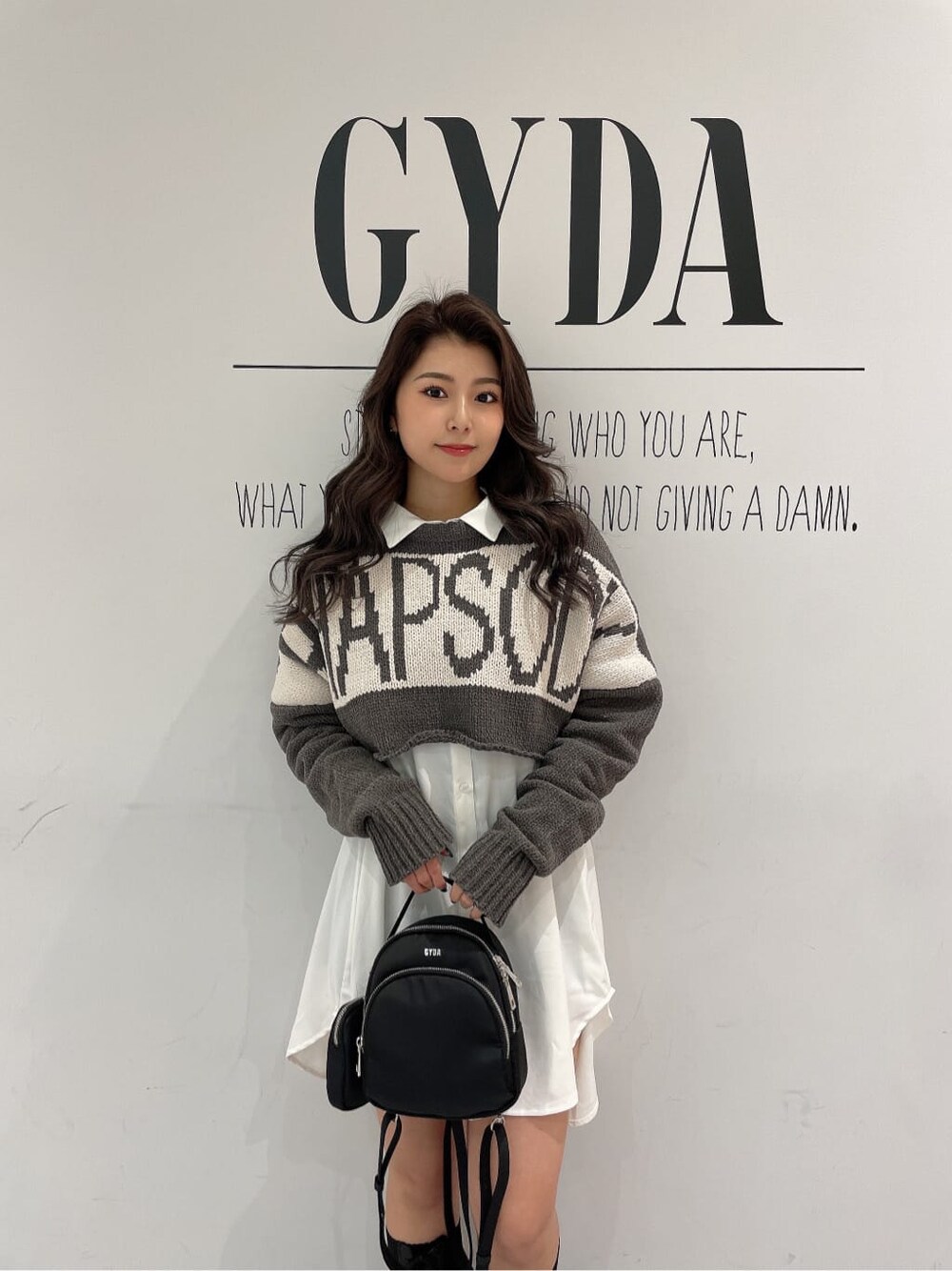 ブラック系のその他シューズ、ブラック系のバックパック/リュック、ホワイト系のシャツ/ブラウスを着用したレディースの冬コーディネートの6枚目の写真