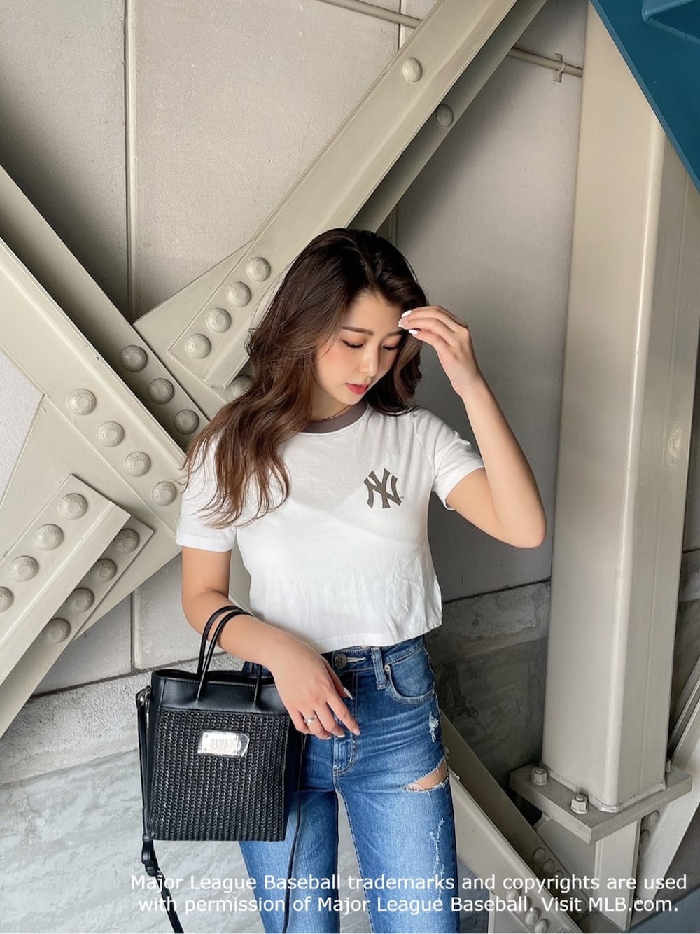 ブラック系のパンプス、ベージュ系のTシャツ/カットソー、ブルー系のデニムパンツを着用したレディースの夏コーディネートの3枚目の写真