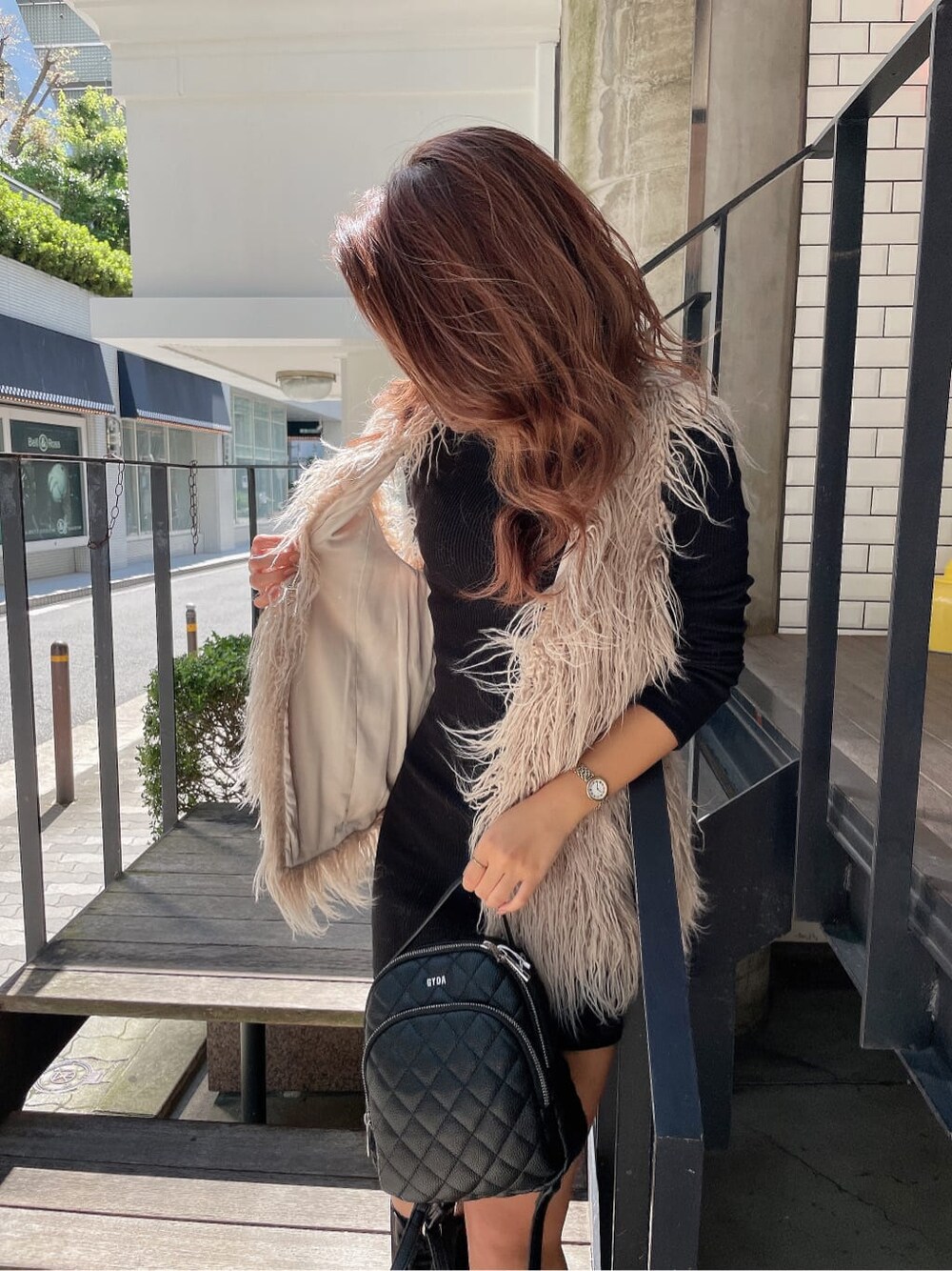 ブラック系のバックパック/リュック、ベージュ系のベスト、ブラック系のブーツを着用したレディースの秋コーディネートの7枚目の写真