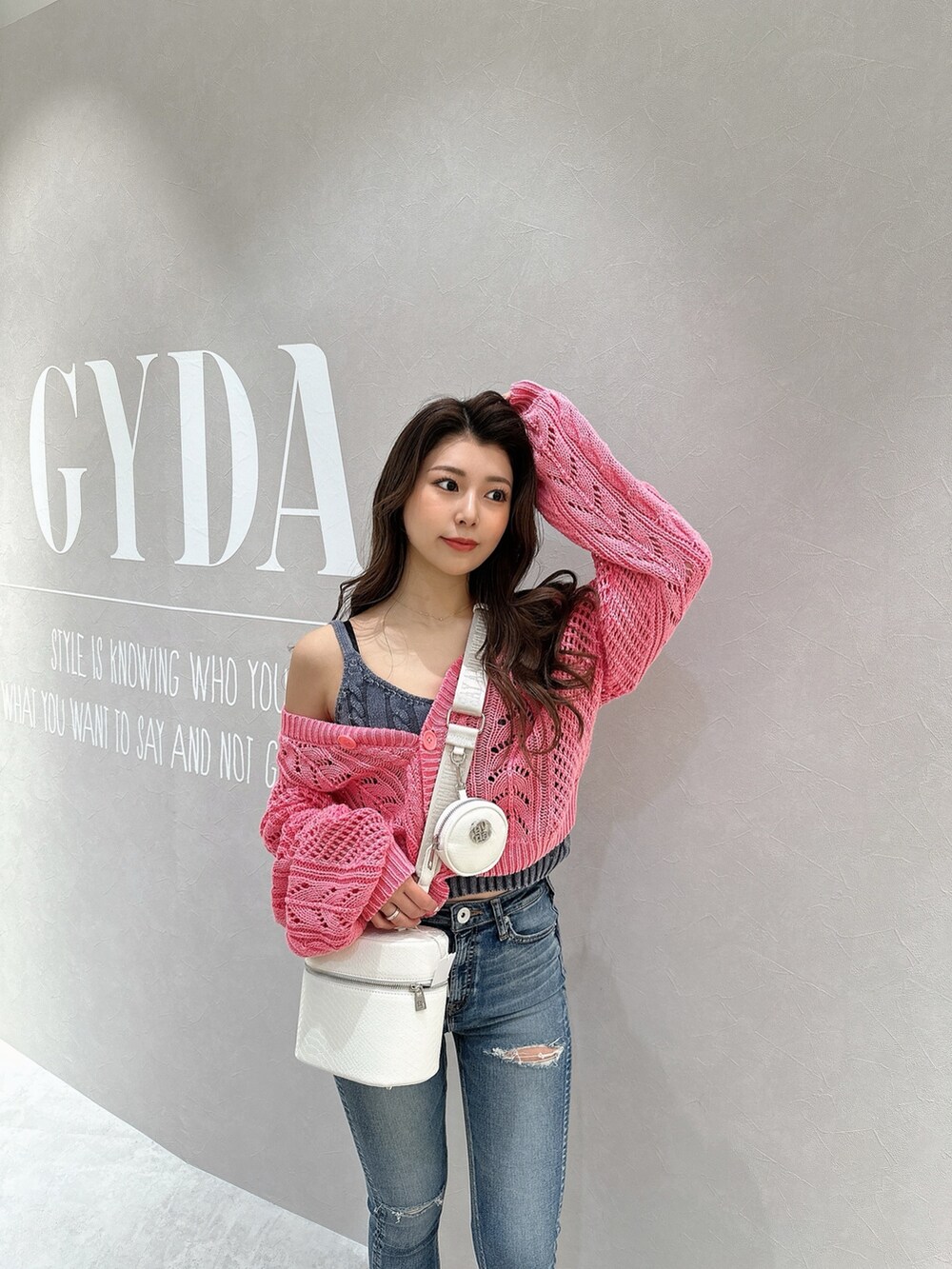 ピンク系のカーディガン/ボレロ、ブルー系のキャミソール、ホワイト系のハンドバッグを着用したレディースの春コーディネートの3枚目の写真