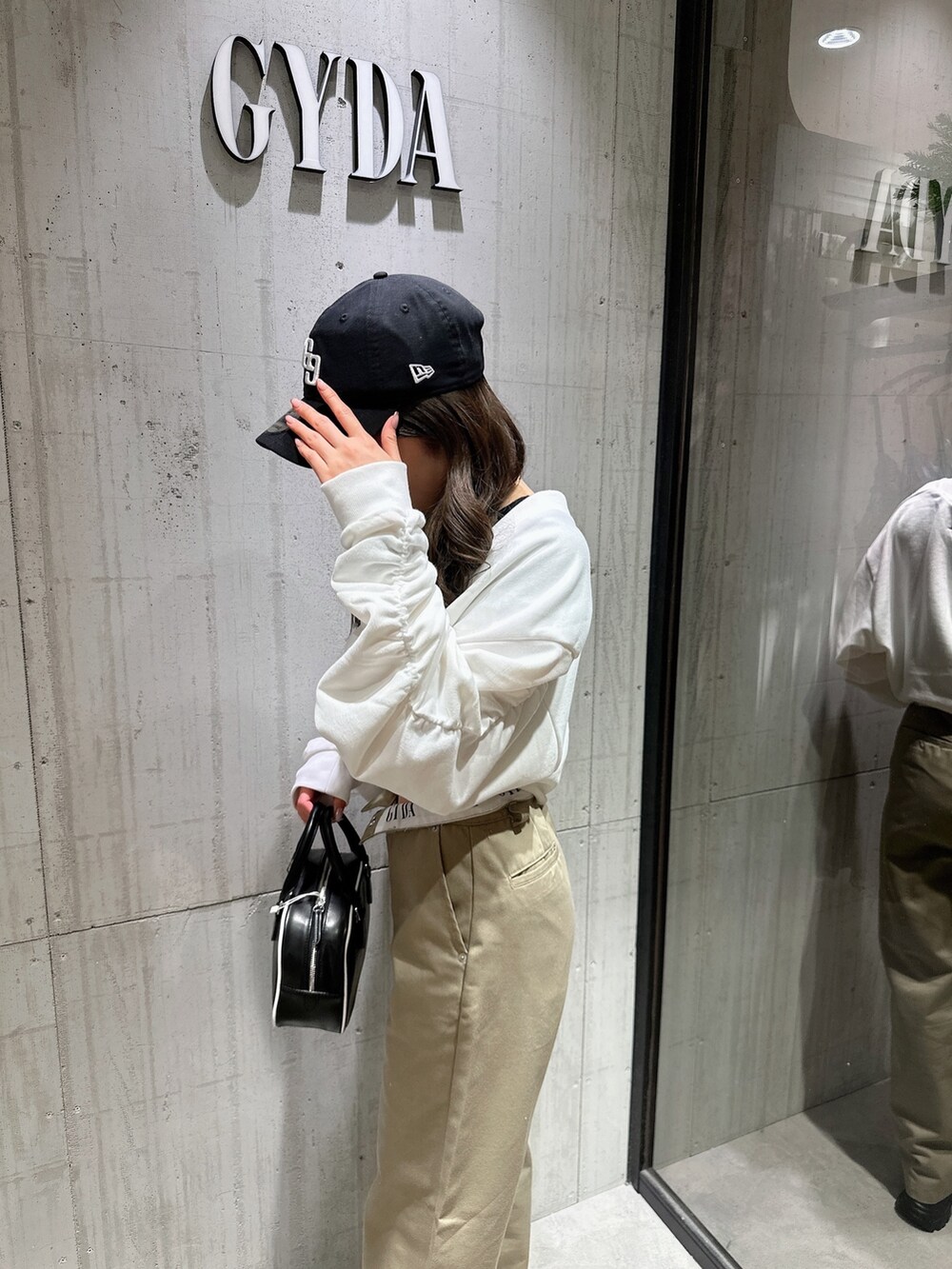 ブラック系のTシャツ/カットソー、ホワイト系のカーディガン/ボレロ、ベージュ系のその他パンツを着用したレディースの春コーディネートの6枚目の写真