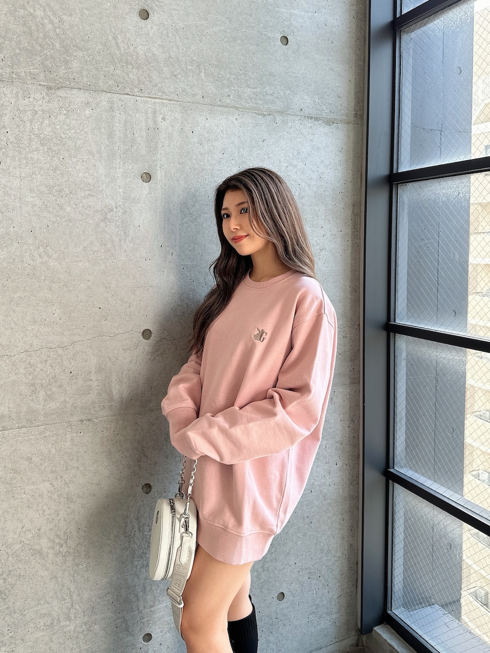 ホワイト系のハンドバッグ、ブラック系のブーツを着用したレディースの秋コーディネートの3枚目の写真