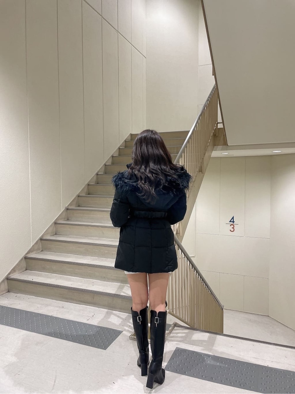 ブラック系のブーツ、ブラック系のその他アウター、ホワイト系のワンピースを着用したレディースの秋コーディネートの2枚目の写真