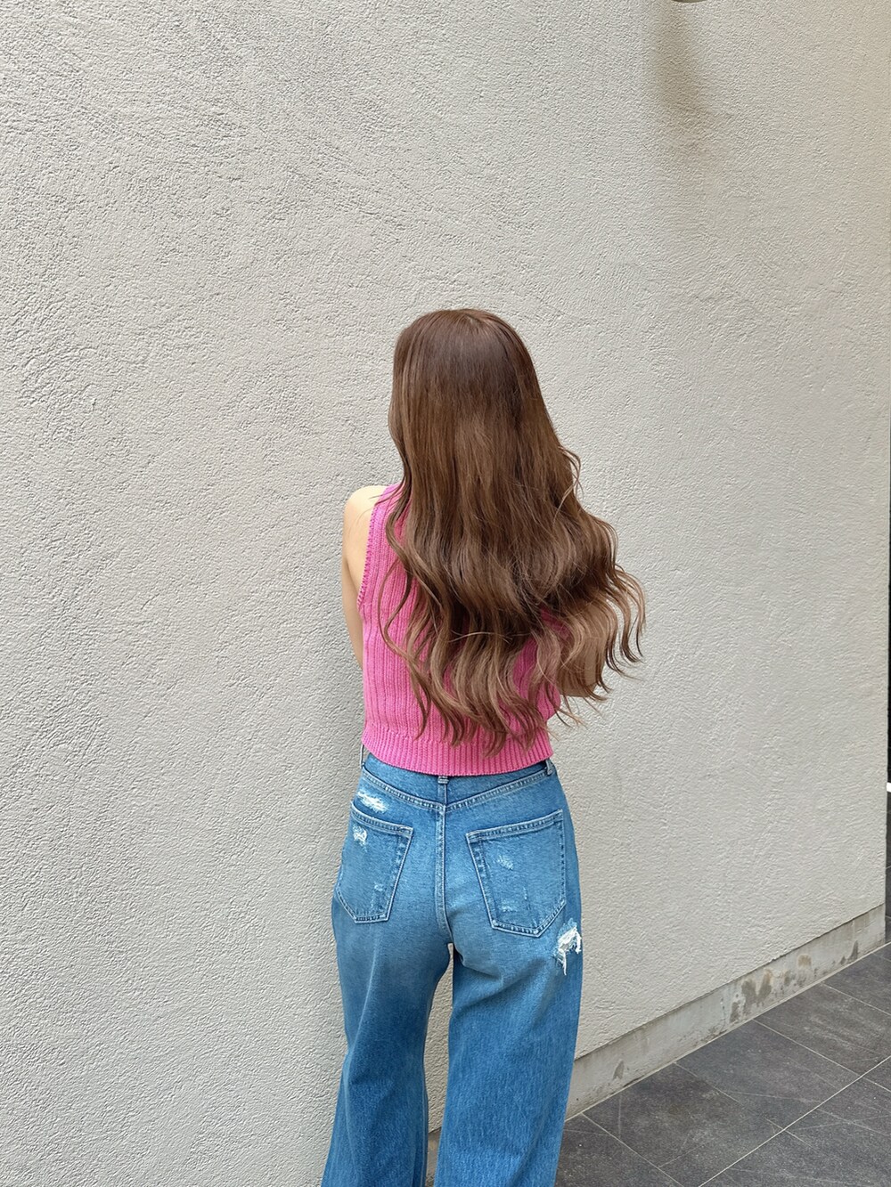 ピンク系のニット/セーター、ブルー系のデニムパンツを着用したレディースの夏コーディネートの4枚目の写真