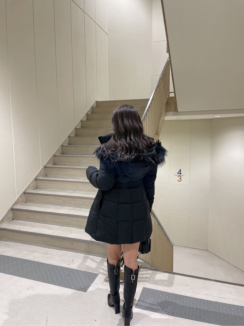 ブラック系のブーツ、ブラック系のその他アウター、ホワイト系のワンピースを着用したレディースの秋コーディネートの4枚目の写真