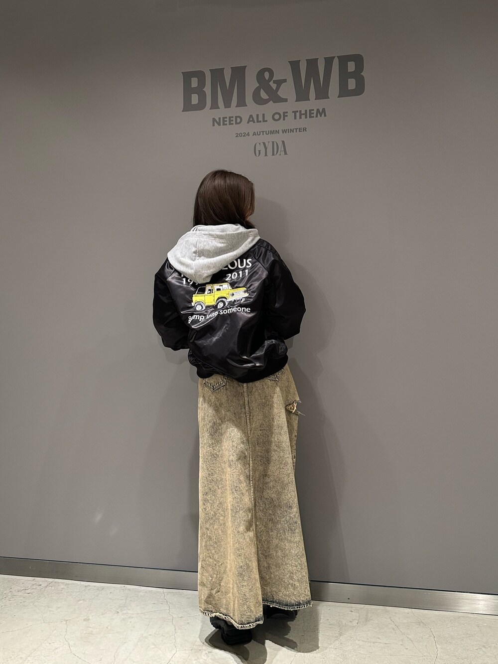 グレー系のパーカー、ブルー系のデニムスカート、ブラック系のブルゾンを着用したレディースの秋コーディネートの3枚目の写真