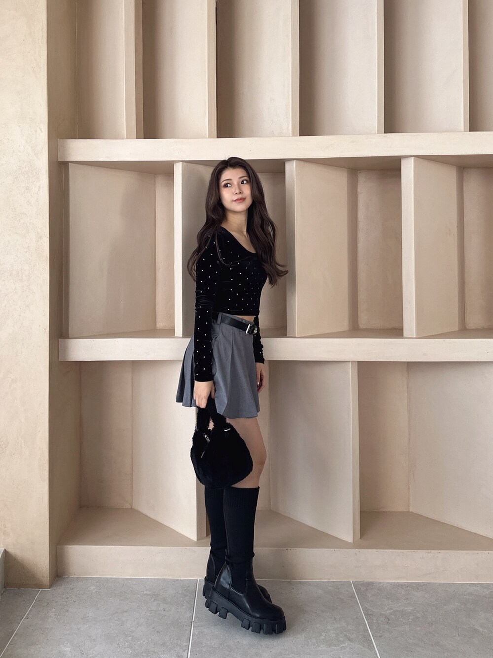 ブラック系のブーツ、ブラック系のTシャツ/カットソー、グレー系のスカートを着用したレディースの秋コーディネートの2枚目の写真