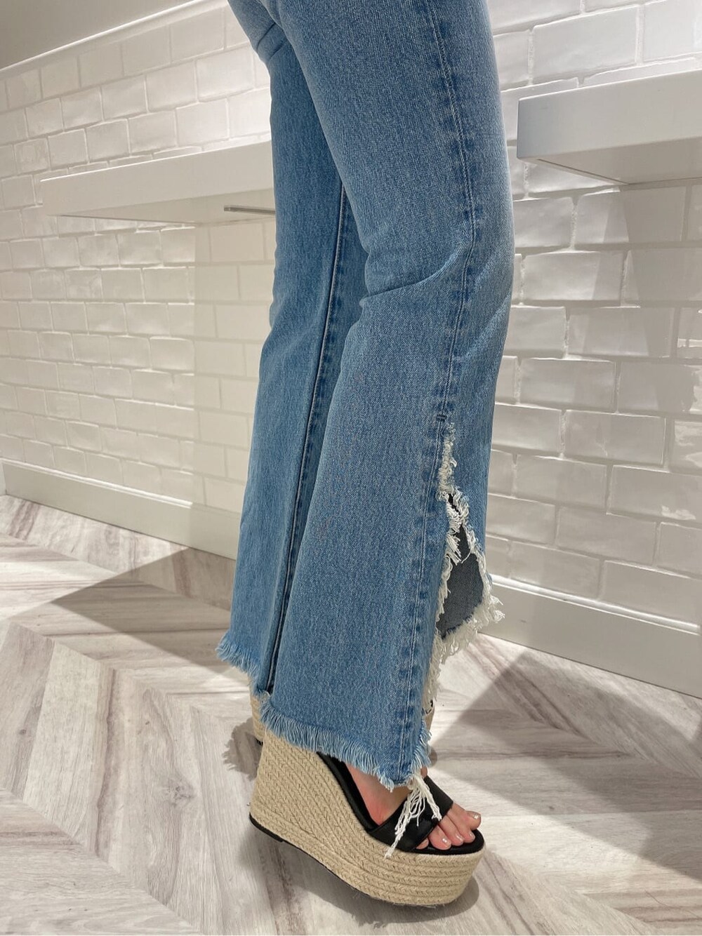 ブラック系のサンダル、ブラック系のTシャツ/カットソー、ブルー系のデニムパンツを着用したレディースの夏コーディネートの6枚目の写真