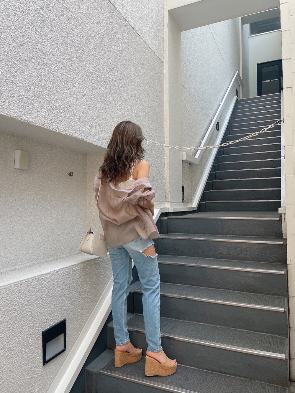 ホワイト系のキャミソール、ホワイト系のキャミソール、ブルー系のデニムパンツを着用したレディースの春コーディネートの3枚目の写真