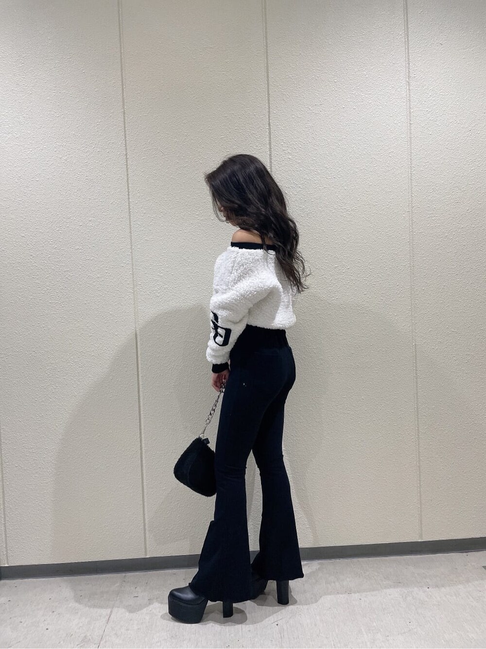 ブラック系のブーツ、ホワイト系のTシャツ/カットソー、ブラック系のスウェットパンツを着用したレディースの秋コーディネートの3枚目の写真