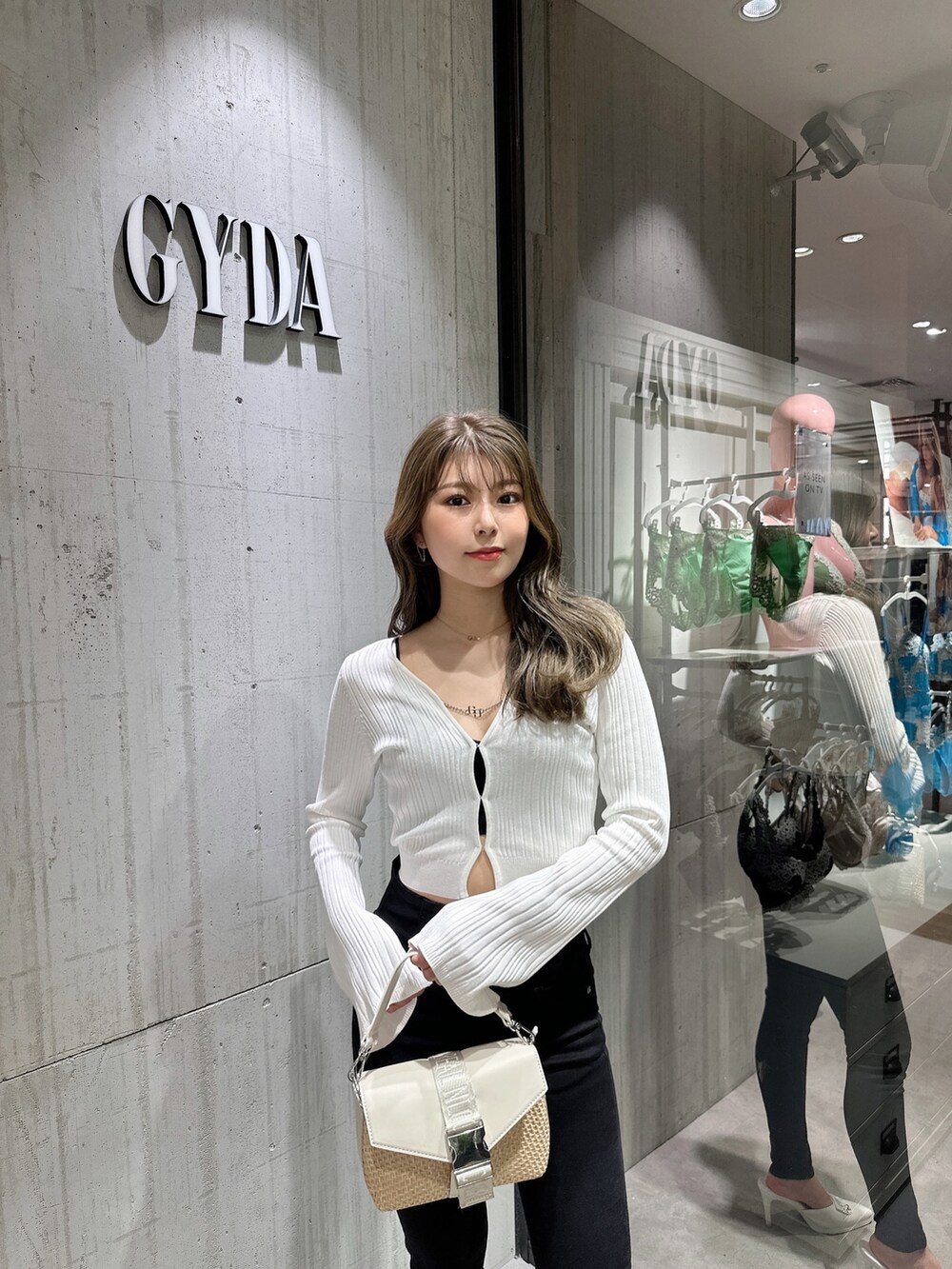 ホワイト系のカーディガン/ボレロ、ブラック系のデニムパンツ、ホワイト系のパンプスを着用したレディースの夏コーディネートの3枚目の写真