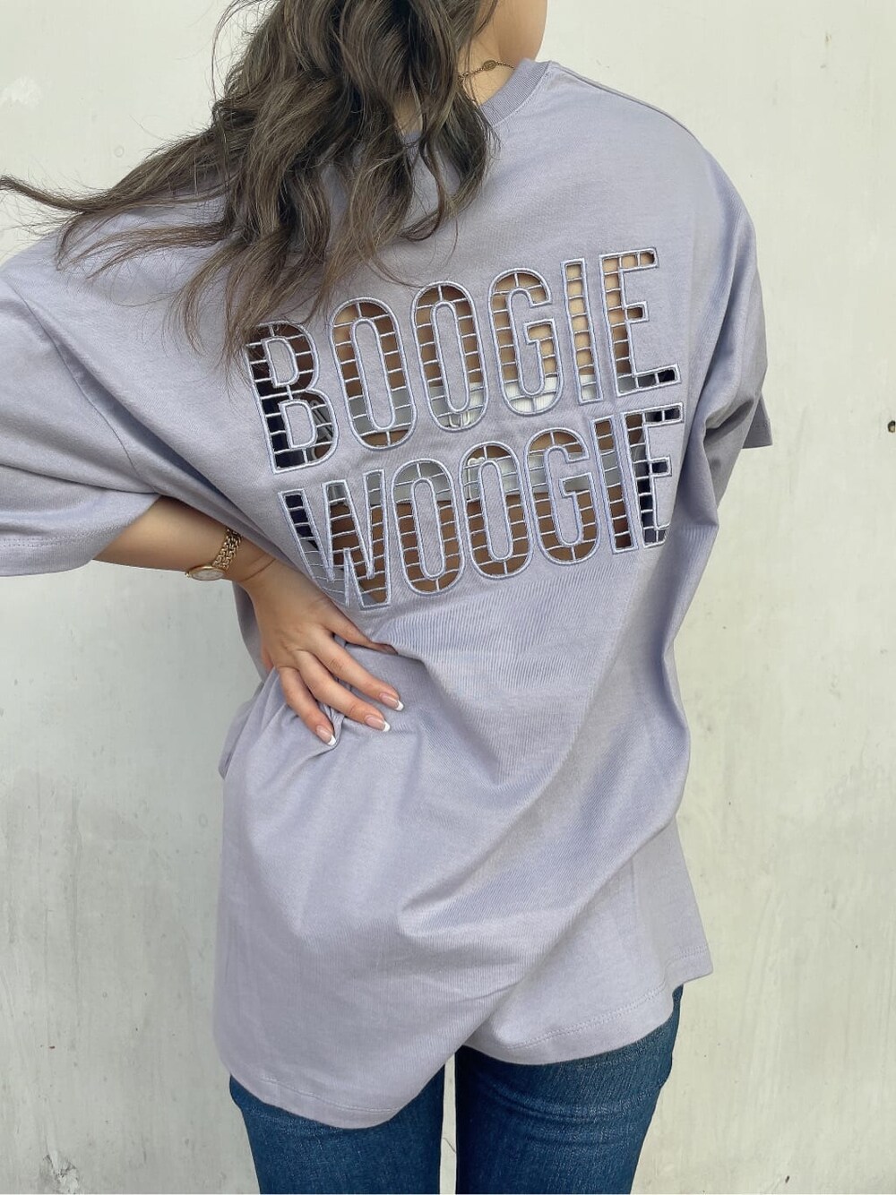 ブルー系のデニムパンツ、ホワイト系のサンダル、パープル系のTシャツ/カットソーを着用したレディースの夏コーディネートの6枚目の写真