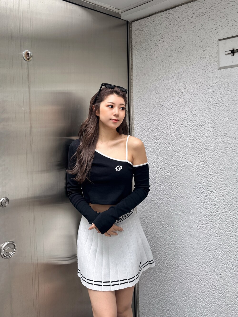 ホワイト系のスカート、ブラック系のTシャツ/カットソー、ブラック系のスニーカーを着用したレディースの冬コーディネートの2枚目の写真