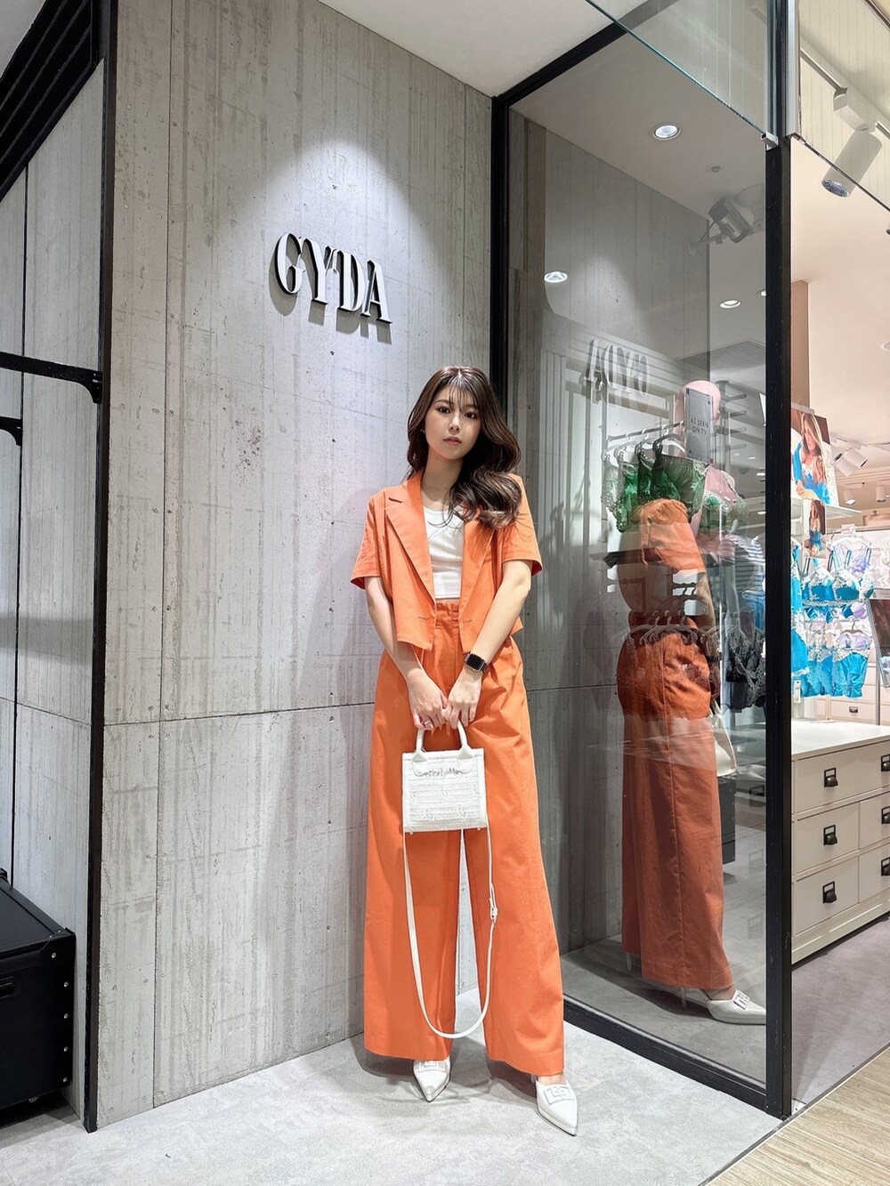 ホワイト系のTシャツ/カットソー、オレンジ系のテーラードジャケット、オレンジ系のスラックスを着用したレディースの春コーディネートの2枚目の写真