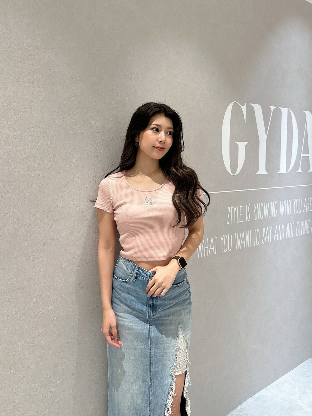 ブルー系のデニムスカート、ホワイト系のサンダル、ピンク系のTシャツ/カットソーを着用したレディースの春コーディネートの5枚目の写真