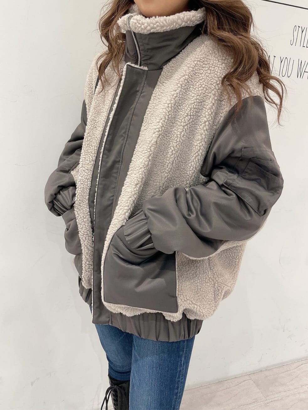 ブラック系のバックパック/リュック、ブラック系のブーツ、ブルー系のデニムパンツを着用したレディースの秋コーディネートの4枚目の写真