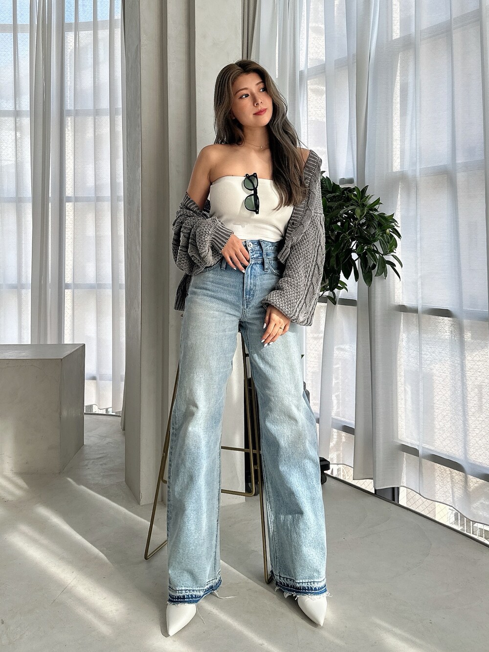 ブルー系のニット/セーター、ブルー系のデニムパンツ、ホワイト系のパンプスを着用したレディースの夏コーディネートの2枚目の写真