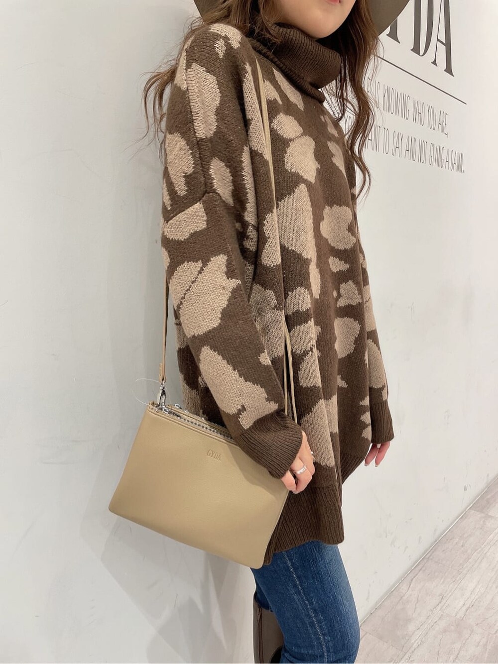 ブラウン系のブーツ、ブルー系のデニムパンツ、ベージュ系のショルダーバッグを着用したレディースの秋コーディネートの9枚目の写真