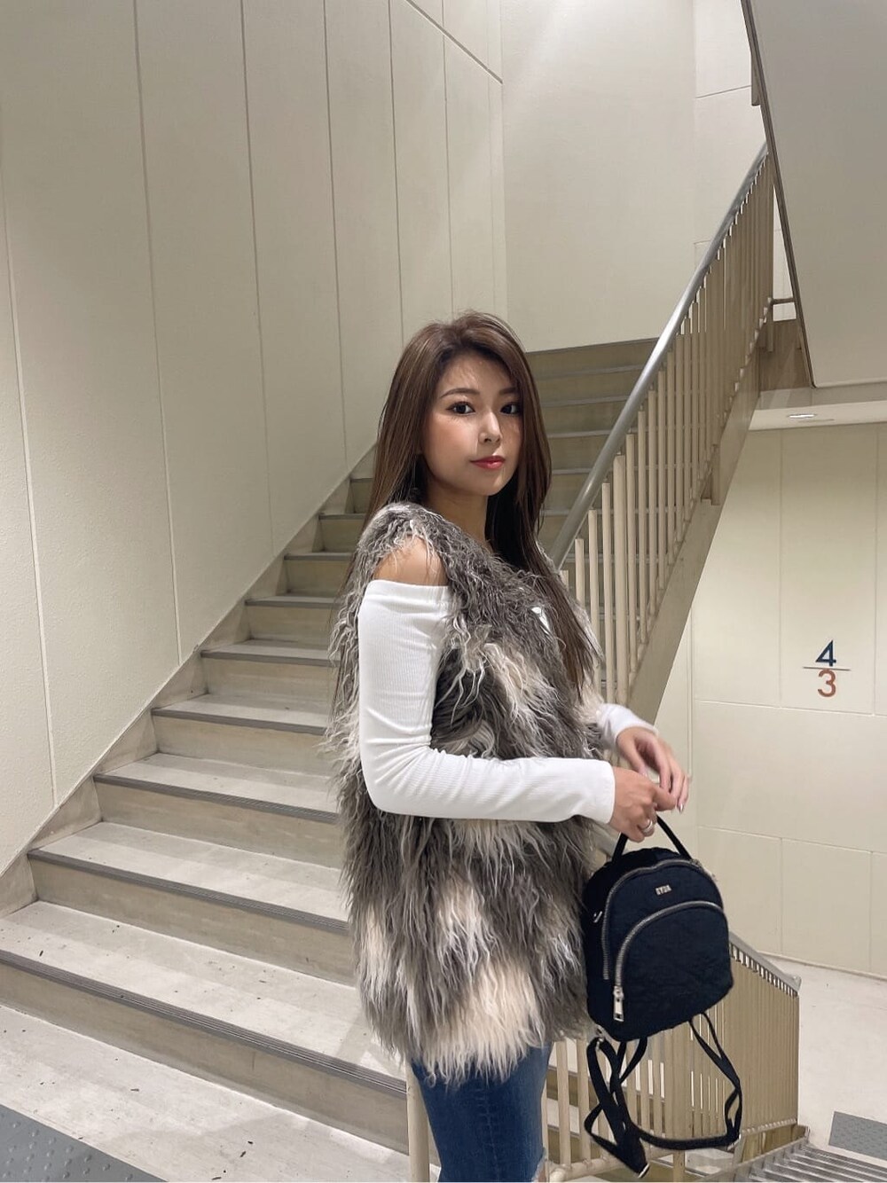 ブラック系のブーツ、ブルー系のデニムパンツ、ブラック系のバックパック/リュックを着用したレディースの秋コーディネートの8枚目の写真