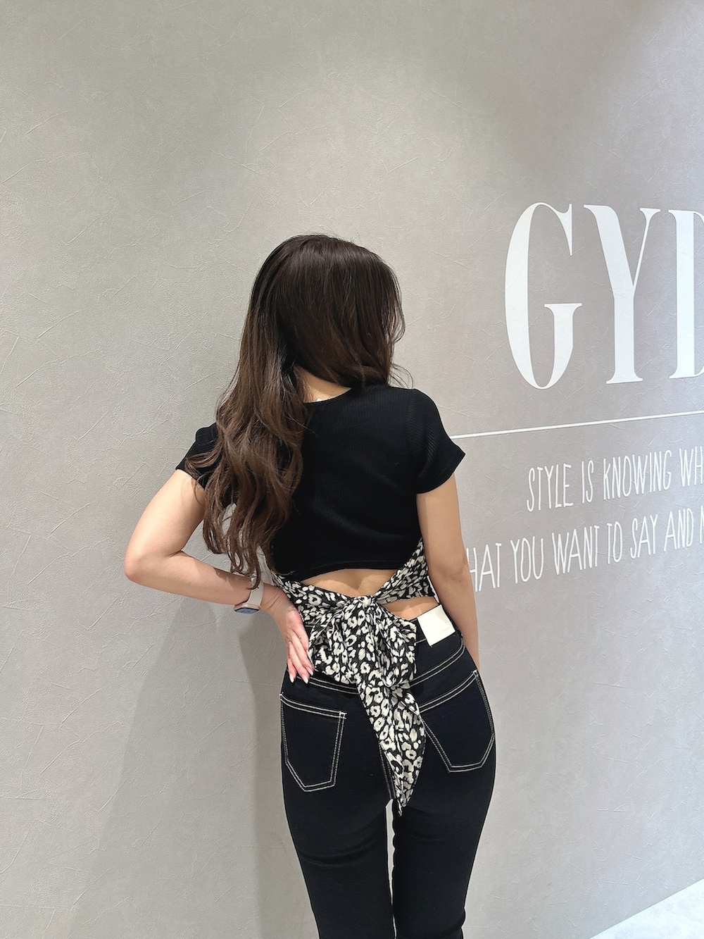 ブラック系のTシャツ/カットソー、ブラック系のデニムパンツ、ブラック系のパンプスを着用したレディースの春コーディネートの6枚目の写真