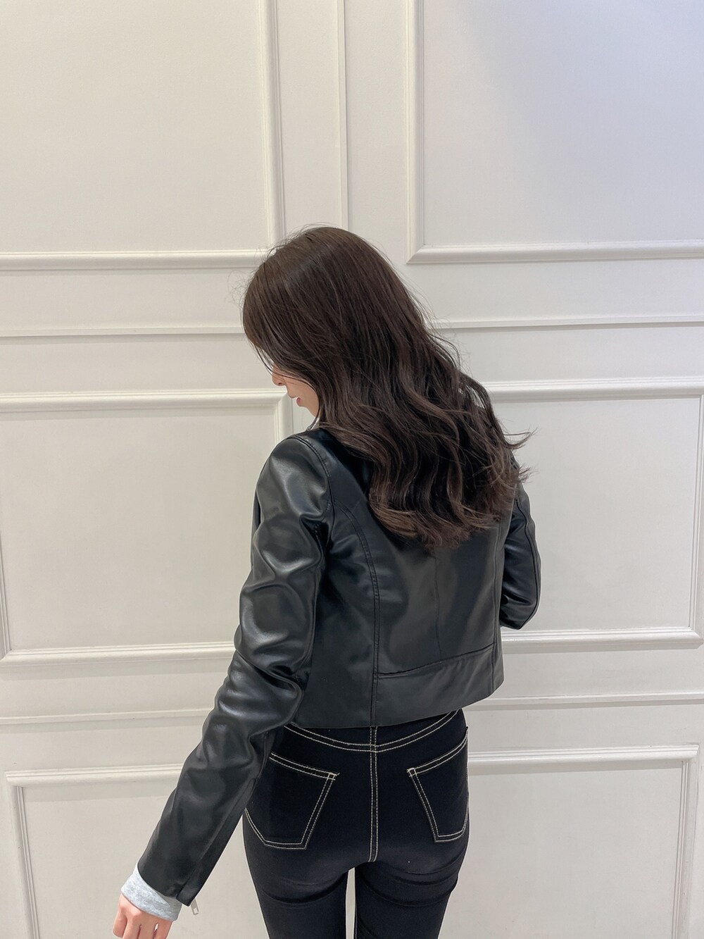 グレー系のTシャツ/カットソー、ブラック系のライダースジャケット、ブラック系のハンドバッグを着用したレディースの冬コーディネートの5枚目の写真