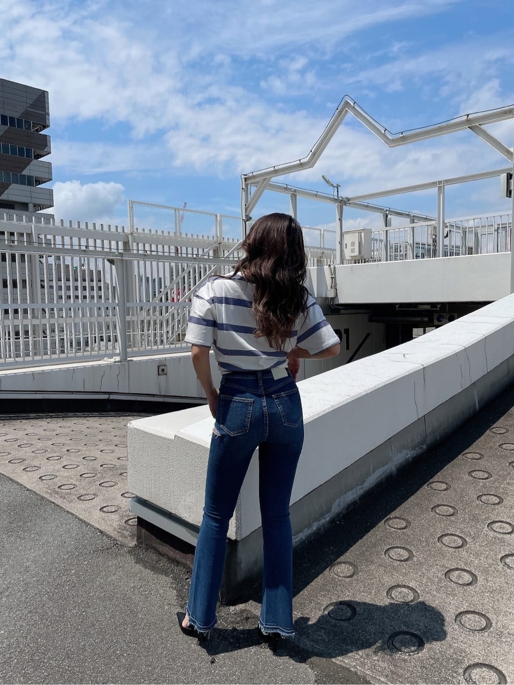 ブラック系のパンプス、ブルー系のデニムパンツ、その他のTシャツ/カットソーを着用したレディースの夏コーディネートの4枚目の写真