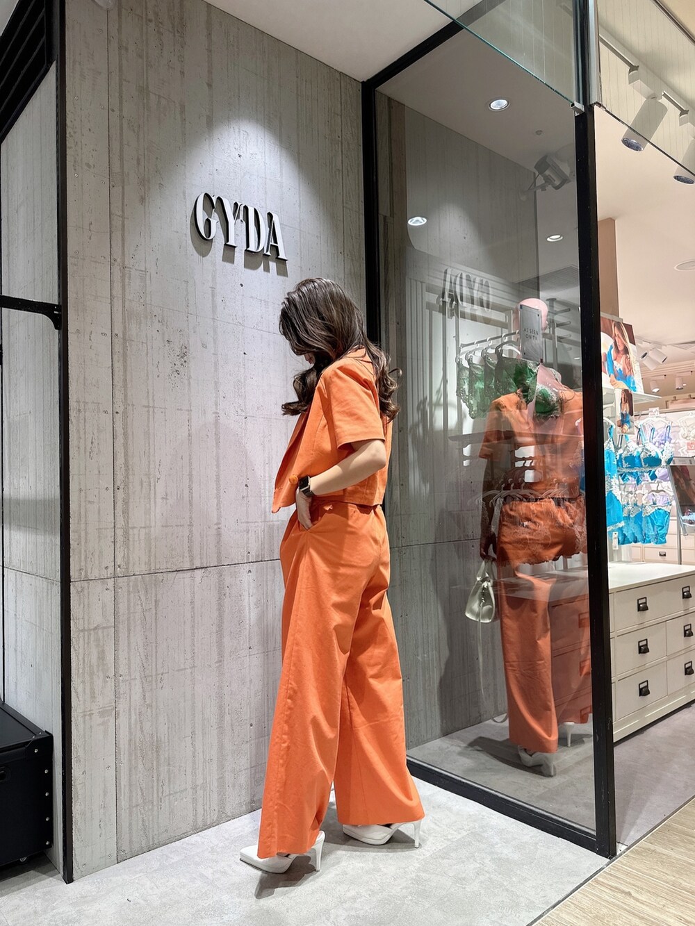 ホワイト系のTシャツ/カットソー、オレンジ系のテーラードジャケット、オレンジ系のスラックスを着用したレディースの春コーディネートの3枚目の写真