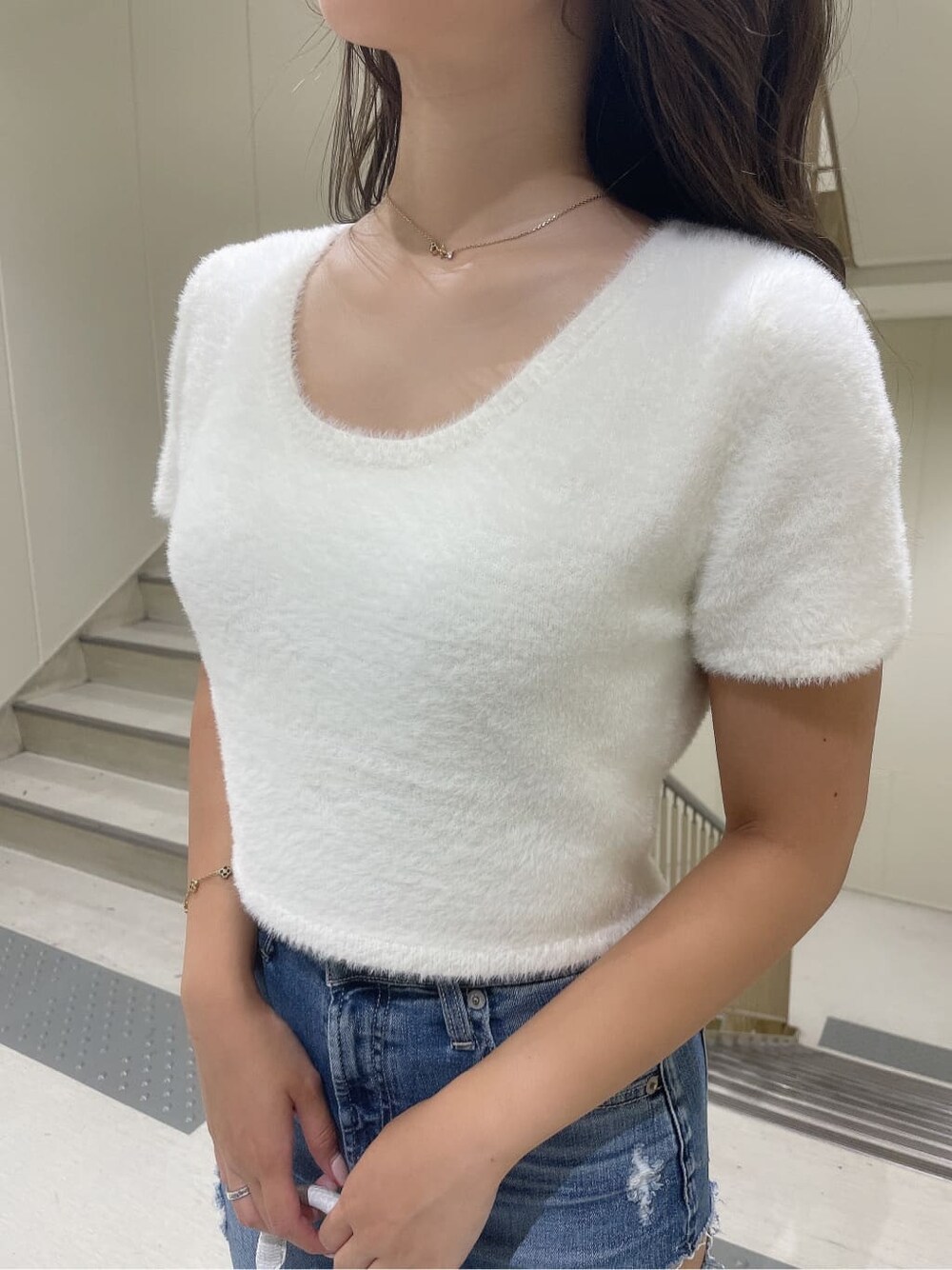 ホワイト系のニット/セーター、ホワイト系のハンドバッグ、ホワイト系のパンプスを着用したレディースの夏コーディネートの7枚目の写真