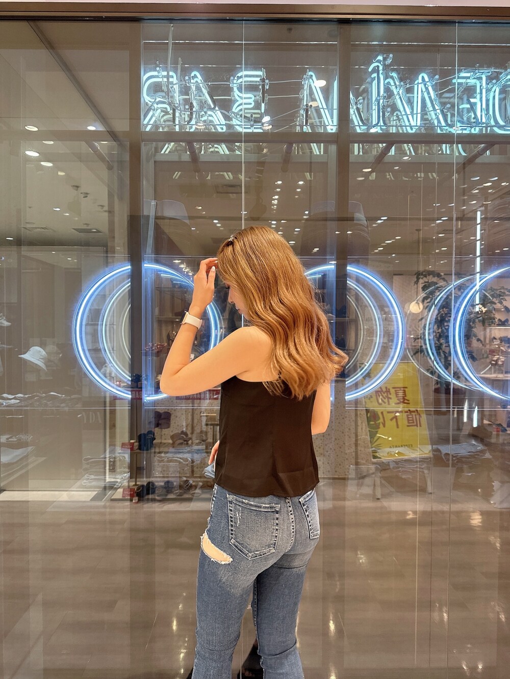 ブルー系のデニムパンツ、ブラック系のサンダル、ブラック系のキャミソールを着用したレディースの夏コーディネートの6枚目の写真