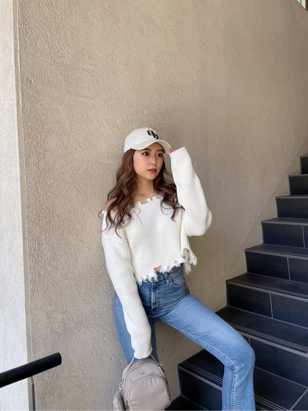 ホワイト系のニット/セーター、ホワイト系のパンプス、ブルー系のデニムパンツを着用したレディースの冬コーディネートの5枚目の写真