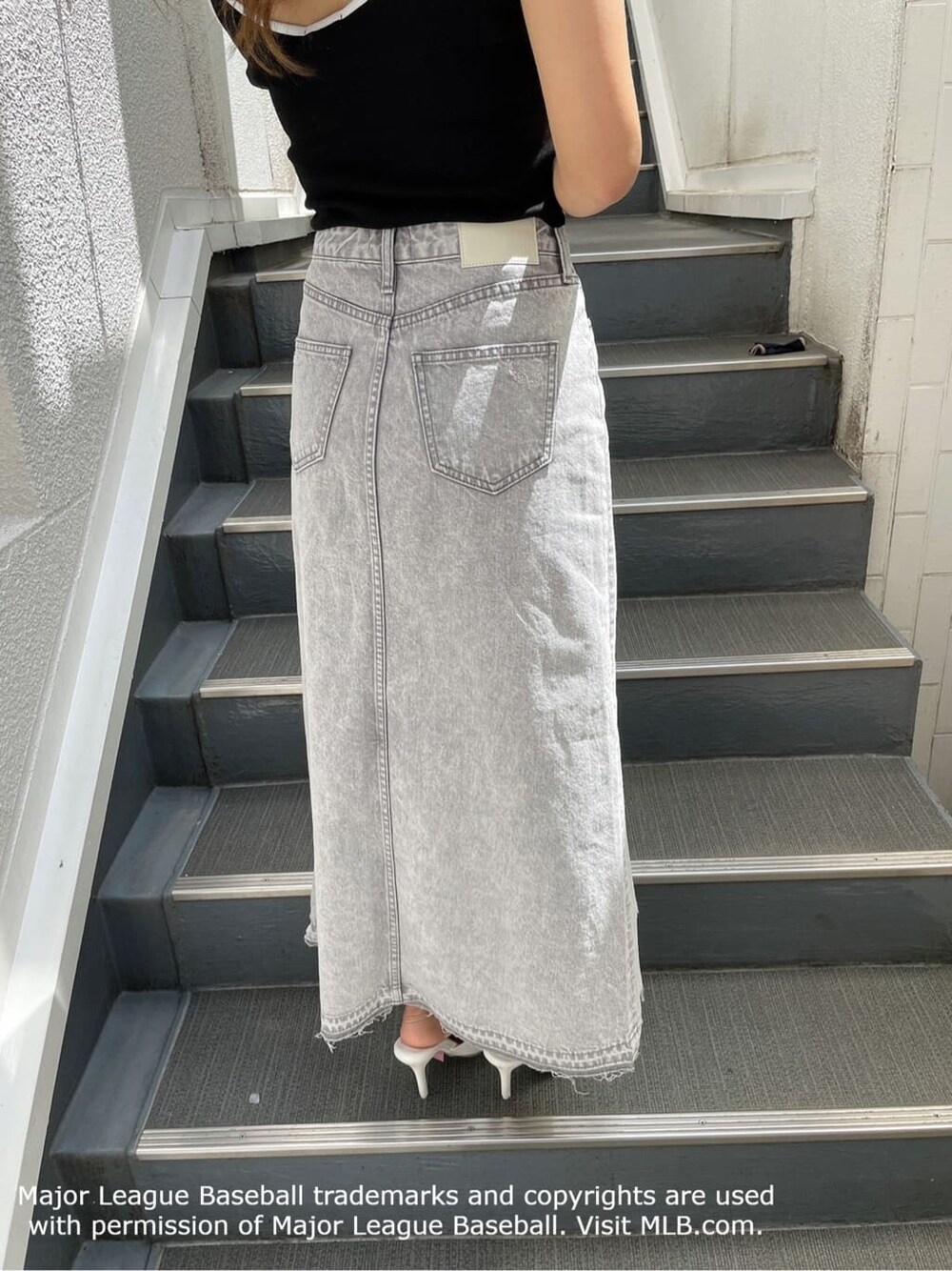 ホワイト系のパンプス、グレー系のデニムスカート、ブラック系のキャミソールを着用したレディースの夏コーディネートの10枚目の写真