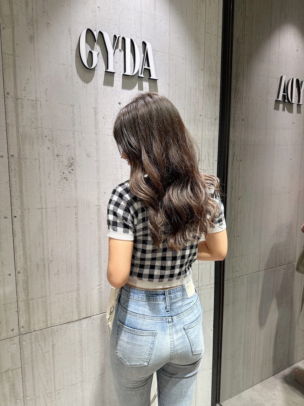 ブラック系のTシャツ/カットソー、ブラック系のカーディガン/ボレロ、ブルー系のデニムパンツを着用したレディースの春コーディネートの5枚目の写真