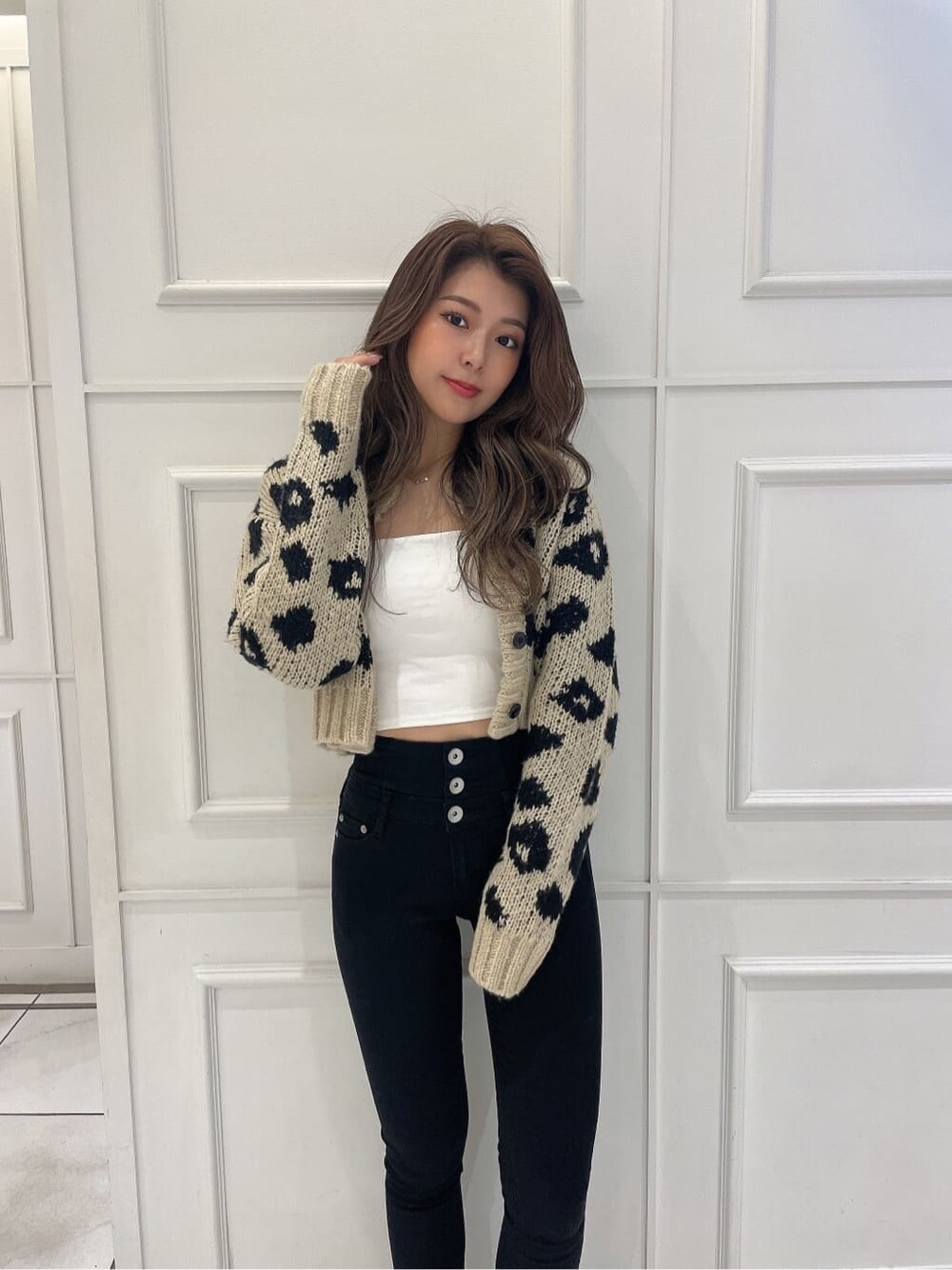 ブラック系のブーツ、ホワイト系のキャミソール、ベージュ系のカーディガン/ボレロを着用したレディースの秋コーディネートの5枚目の写真