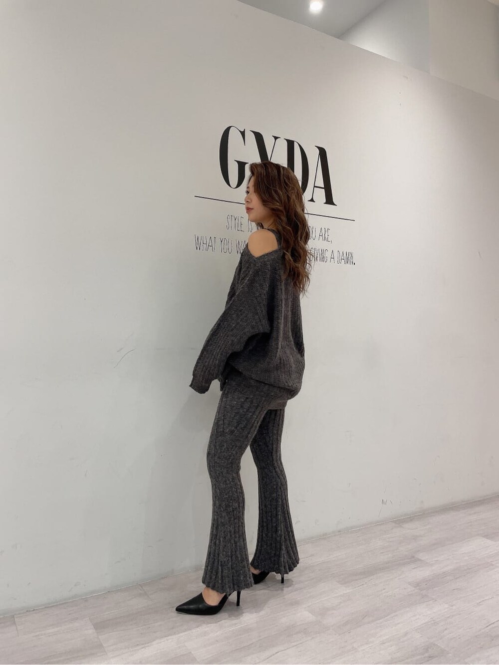 ブラック系のパンプス、グレー系のその他パンツ、ブラック系のショルダーバッグを着用したレディースの秋コーディネートの2枚目の写真