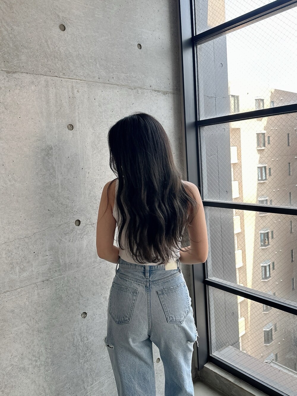 ホワイト系のパンプス、ホワイト系のタンクトップ、ブルー系のデニムパンツを着用したレディースの夏コーディネートの8枚目の写真