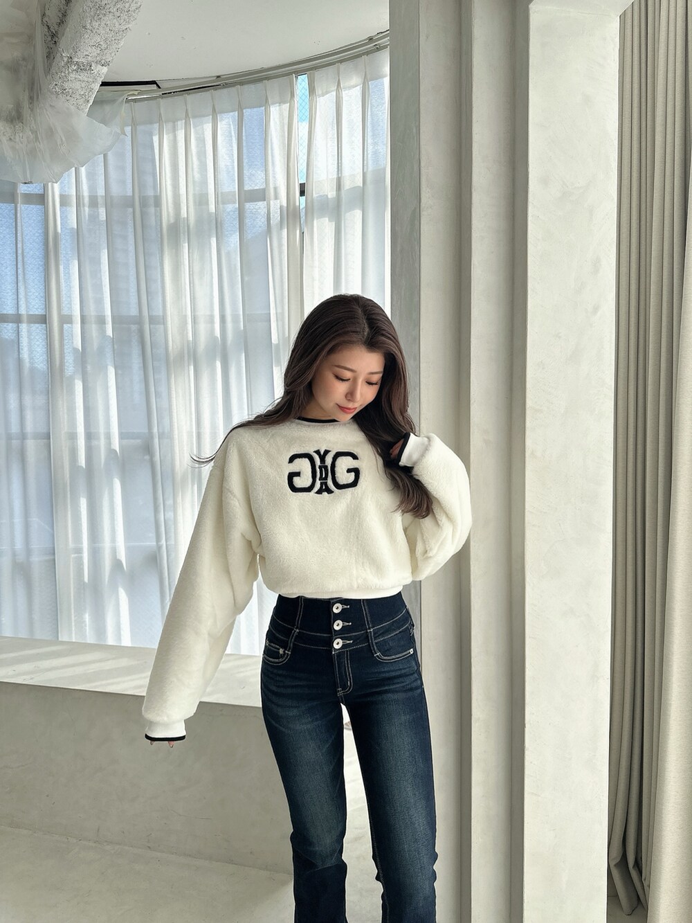 ブラック系のブーツ、ブルー系のデニムパンツ、ホワイト系のTシャツ/カットソーを着用したレディースの秋コーディネートの2枚目の写真