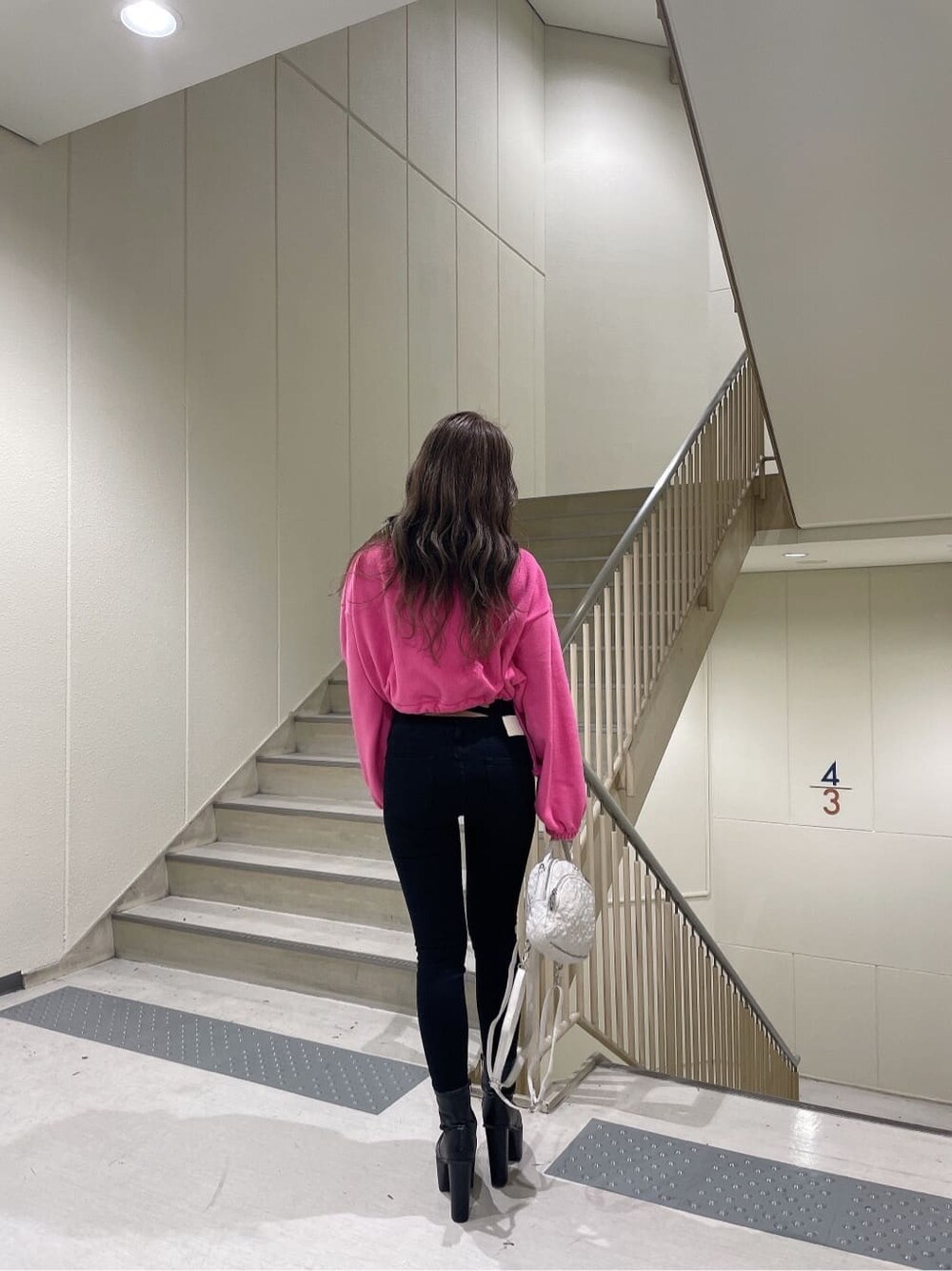 ブラック系のブーツ、ピンク系のTシャツ/カットソー、ブラック系のデニムパンツを着用したレディースの秋コーディネートの2枚目の写真