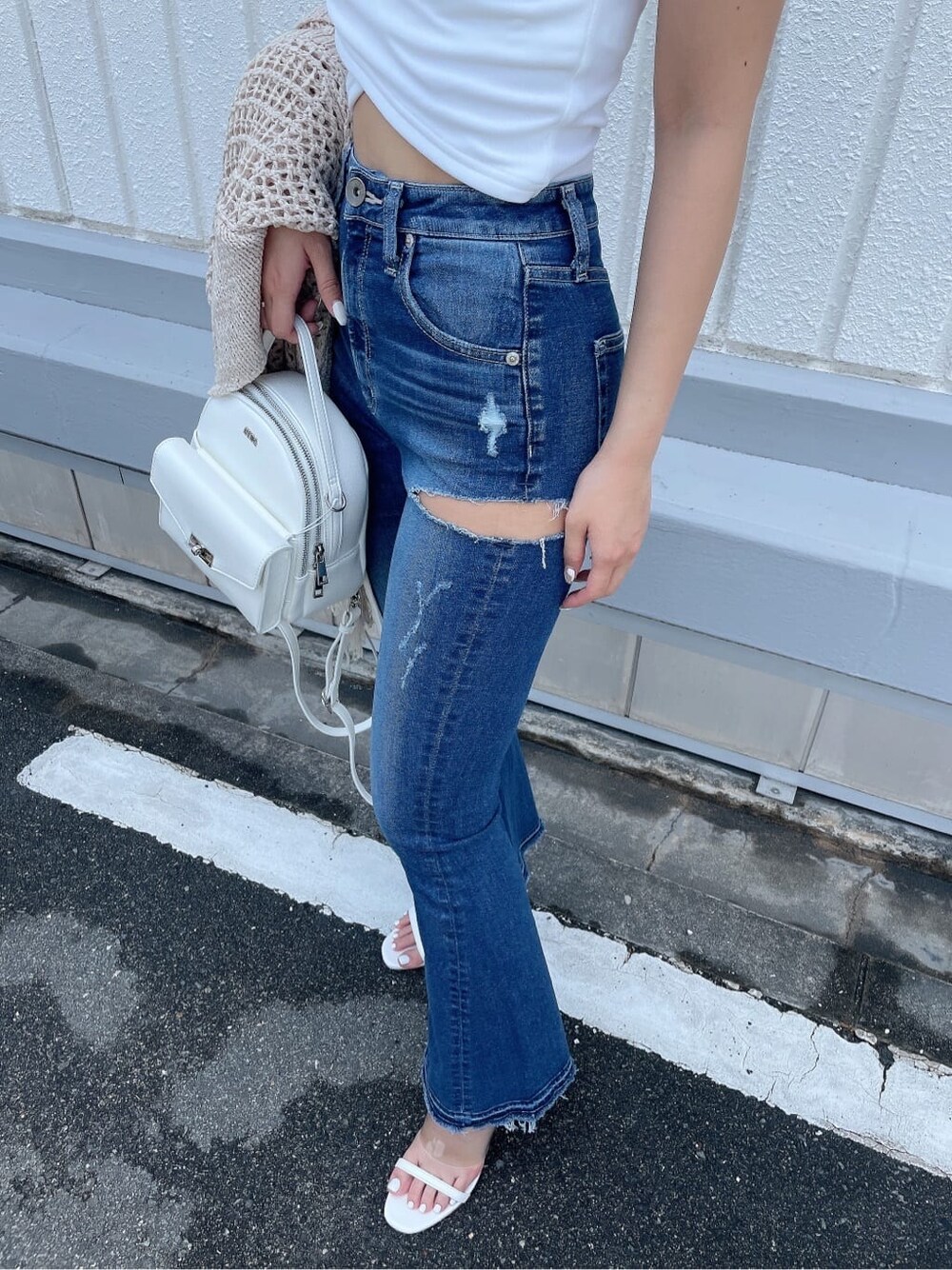 ホワイト系のサンダル、ブルー系のデニムパンツ、ホワイト系のハンドバッグを着用したレディースの夏コーディネートの7枚目の写真